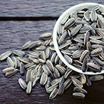 A cup of sunflower seeds overflowing. Sunflower seeds promote cardiovascular health and promote healthy cholesterol levels.