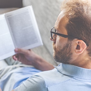 A man focusing on reading a book. Increased focus is a benefit of lithium.