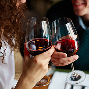 A couple drinking red wine together.