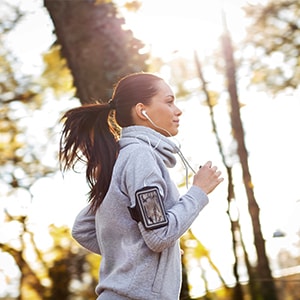 A woman jogging on a nature trail.