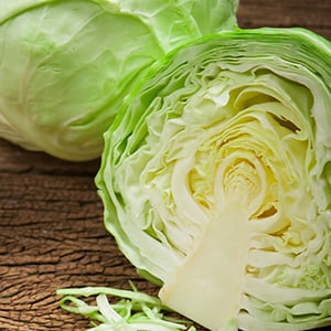 A cabbage cut in half. Cabbage is a nutrient-rich alkaline food, which can serve to prepare delicious vegan recipes.