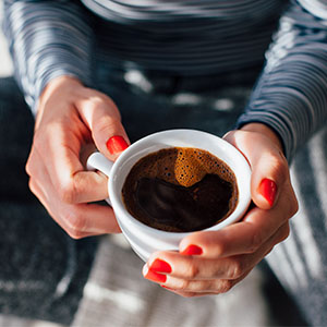 A woman drinking a cup of coffee.