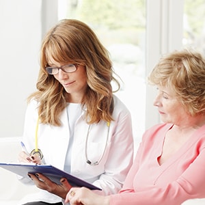 A woman with her doctor speaking with her doctor about her frequent urination symptoms.