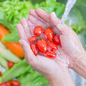 A woman washing fresh vegetables.