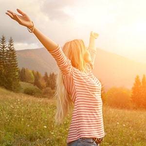 A woman in a field during sunrise.