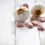 A table covered with garlic. Consuming foods like garlic can help reduce gas.