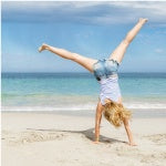 A woman cartwheeling on the beach. I recommend this list of supplements such as B12 and iodine to help boost your energy.