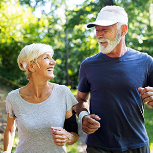 Man and woman jogging together in a green scenery.