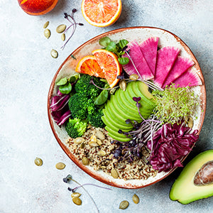 A colorful bowl of vegetables over a textured background.