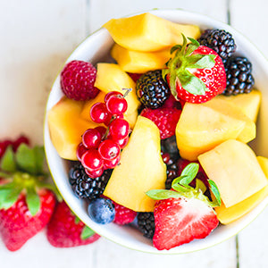 A bowl of colorful, mixed fruit.